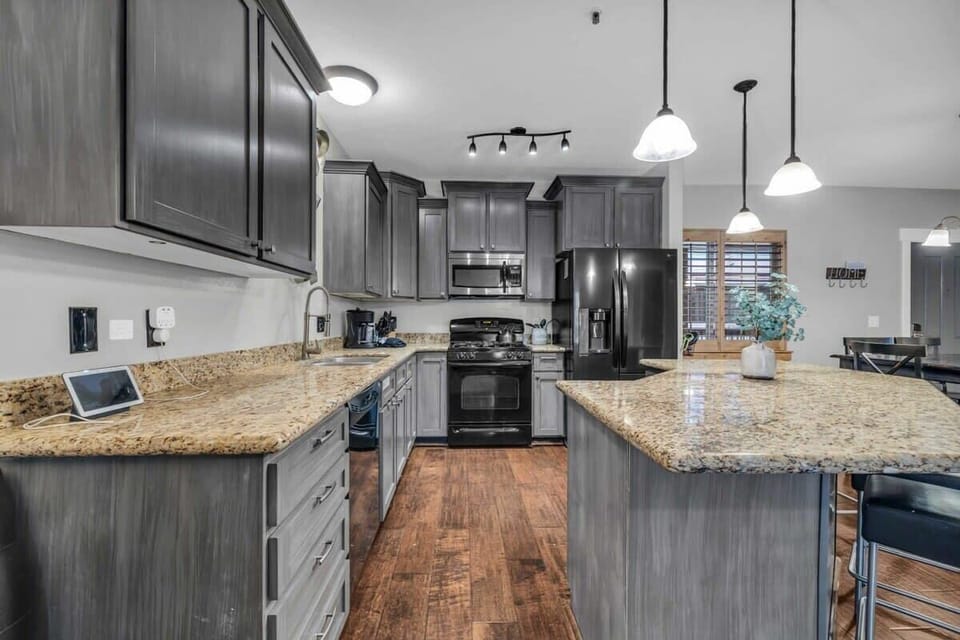 The fully equipped kitchen is a beautiful space with lovely granite countertops, stylish lighting fixtures, and a full range of cookware to prepare your culinary creations with.