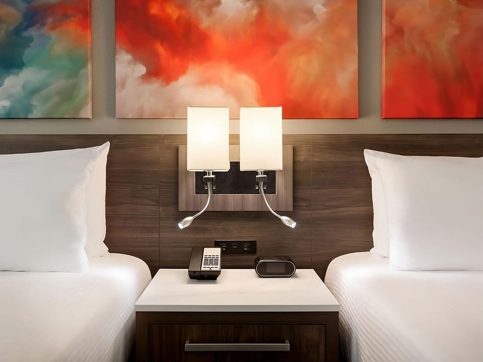 Unwind between two plush beds with warm, glowing lights.