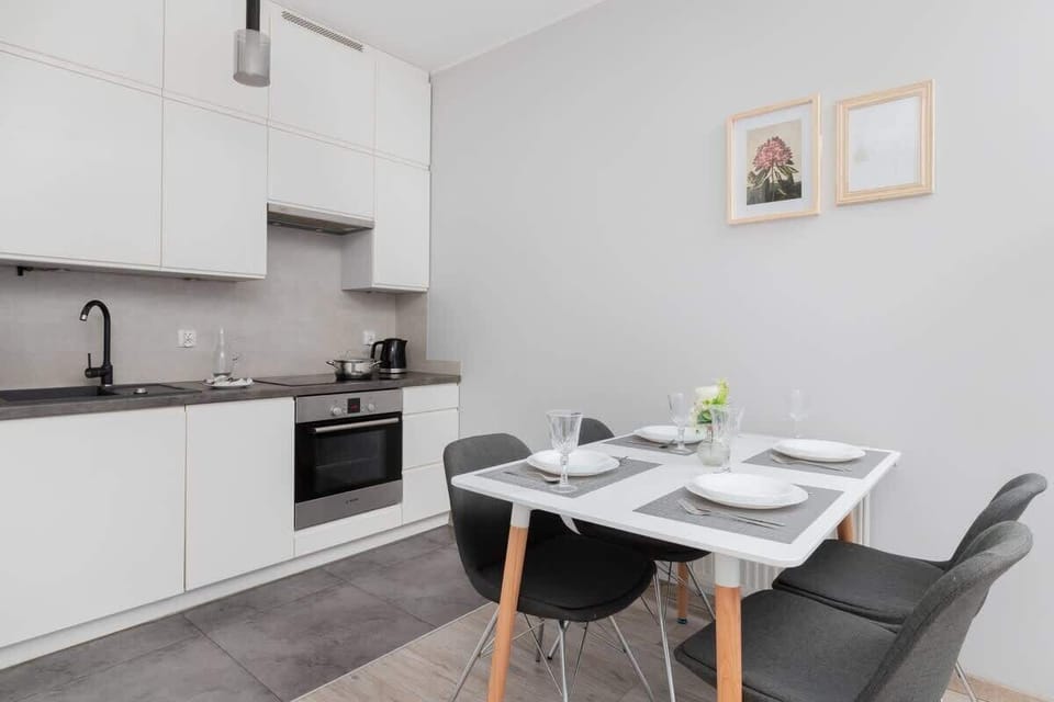 Kitchen with white cabinets, dining area, and built-in oven.
