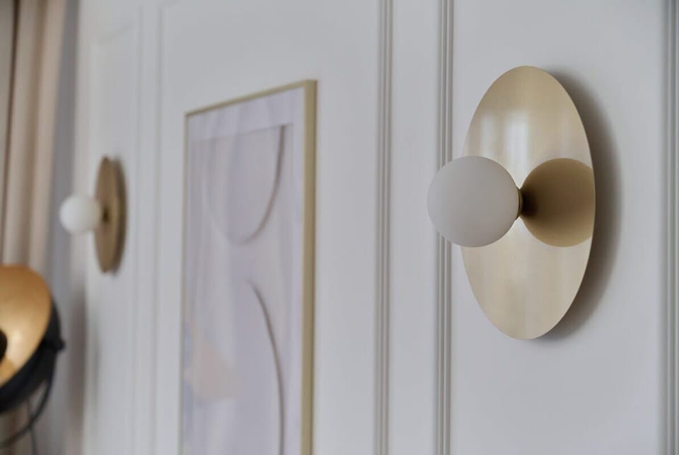 Close-up of gold door handles and minimalist wall art.
