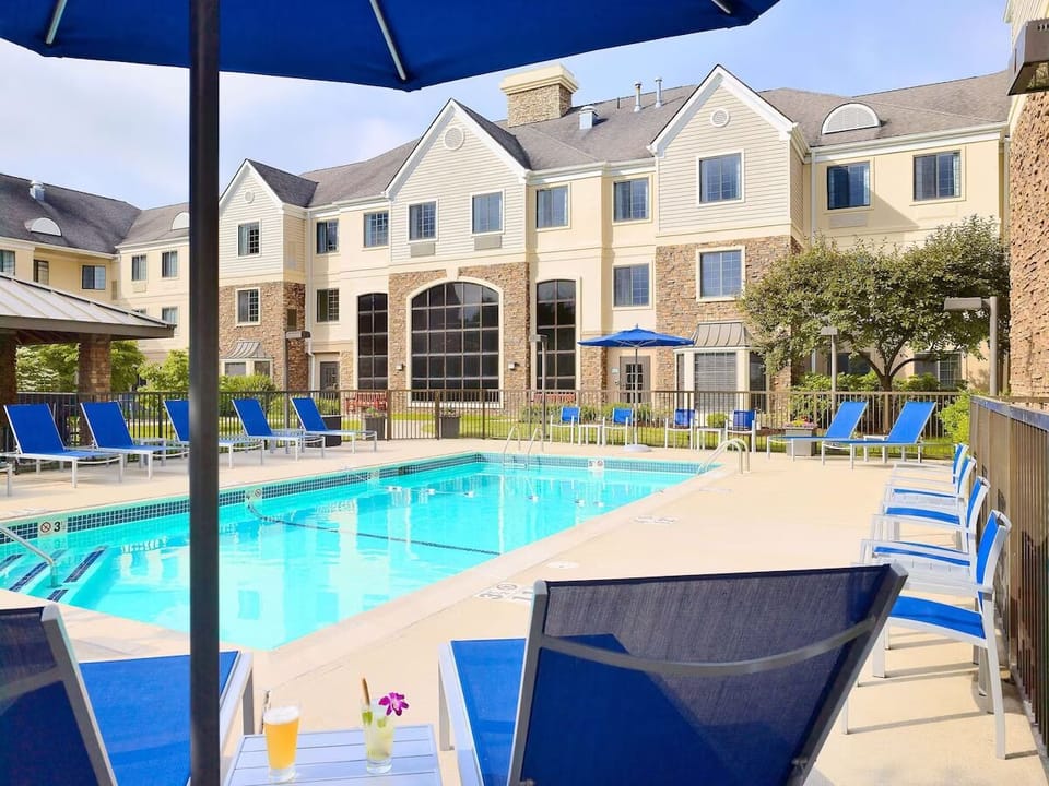 Unwind poolside under umbrellas with sparkling resort-style water views.
