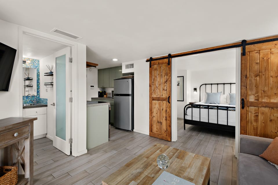 This property features an Open Layout with a seamless flow between the living area, kitchen, and bedroom, enhanced by rustic sliding Wood Doors for charm and Privacy.