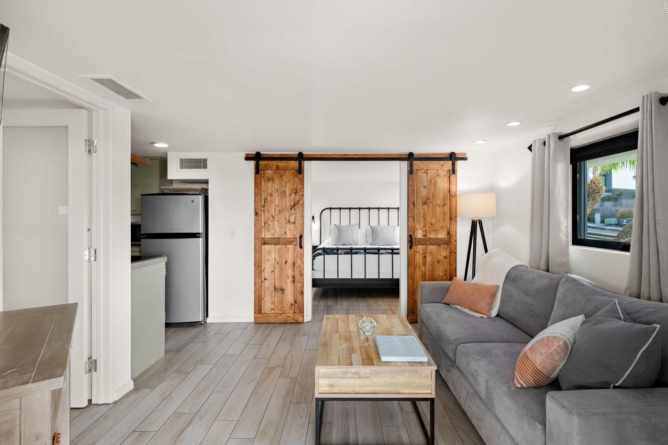 Modern, minimalist Living/Kitchen area with a convertible Sofa Bed and an adjustable coffee table for Dining.
