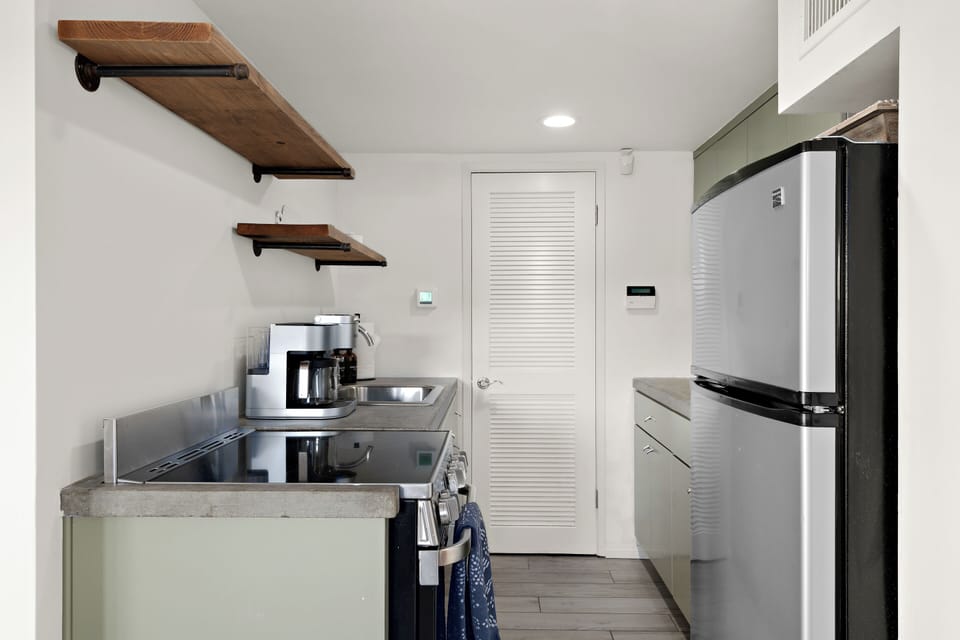 Compact and functional Kitchen featuring a smart design with modern appliances, maximizing space and efficiency while providing all the essentials for your stay.