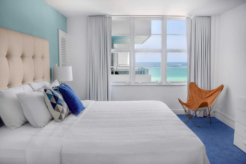 Relax into crisp linens beside sunlit windows and sea.