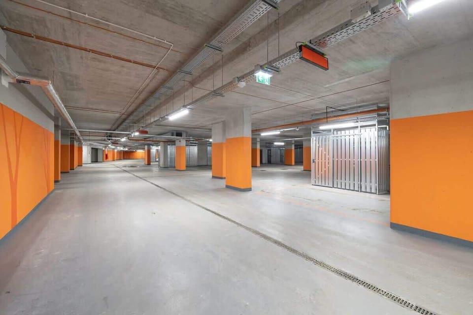 Underground parking with bright lighting and orange accents.
