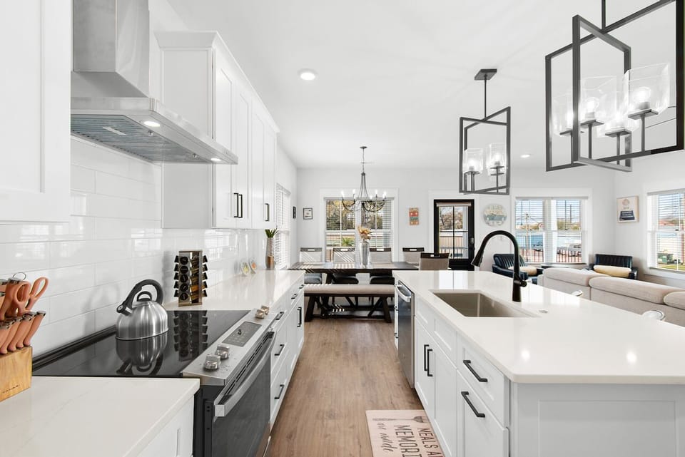 Step into your gleaming gourmet kitchen, where crisp white cabinets and quartz countertops invite culinary adventures with every modern convenience at your fingertips.