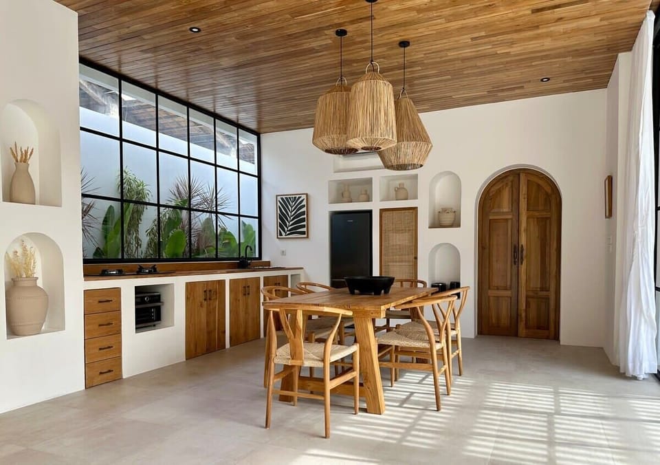 Fully equipped kitchen with fridge, water dispenser, cook top, oven, and a dining table 