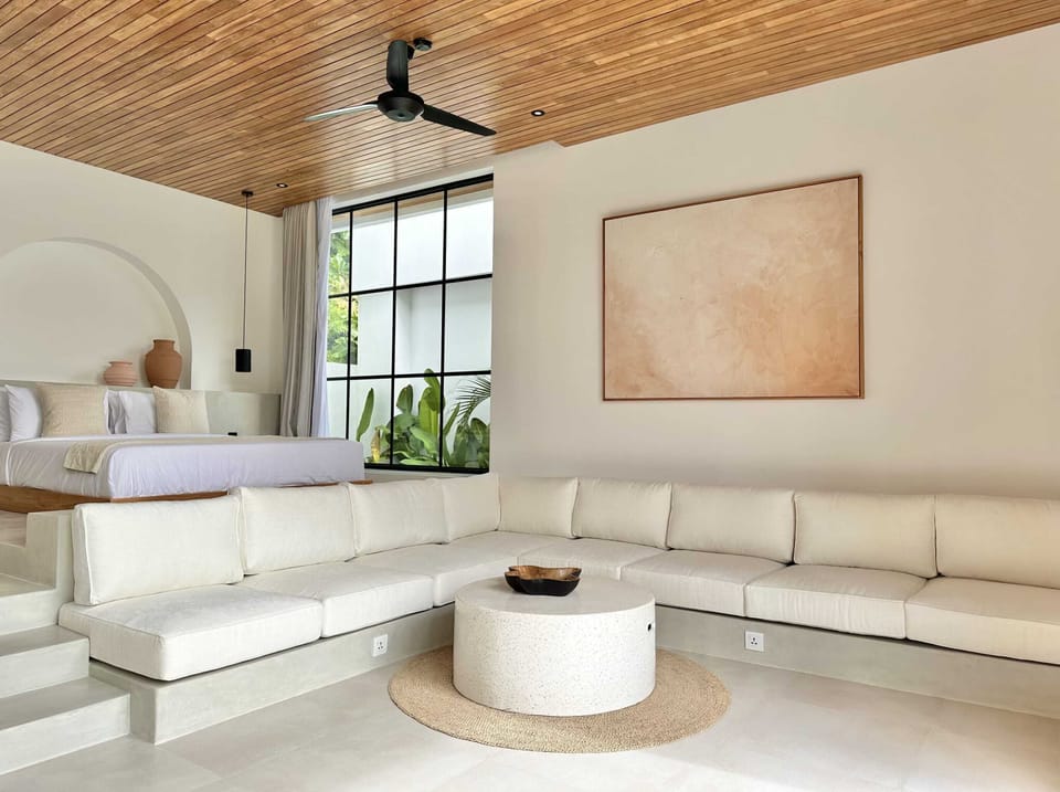 Large white lounge with a Tv and a pool view
