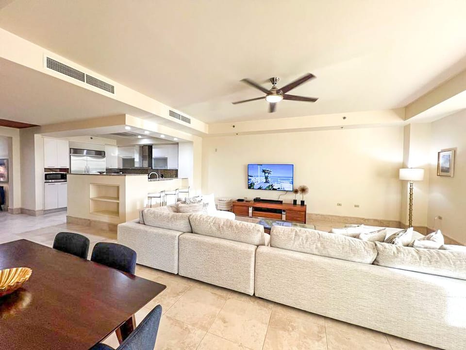 Living room: Deep-cushion, sectional couches adjacent to a glass coffee table
