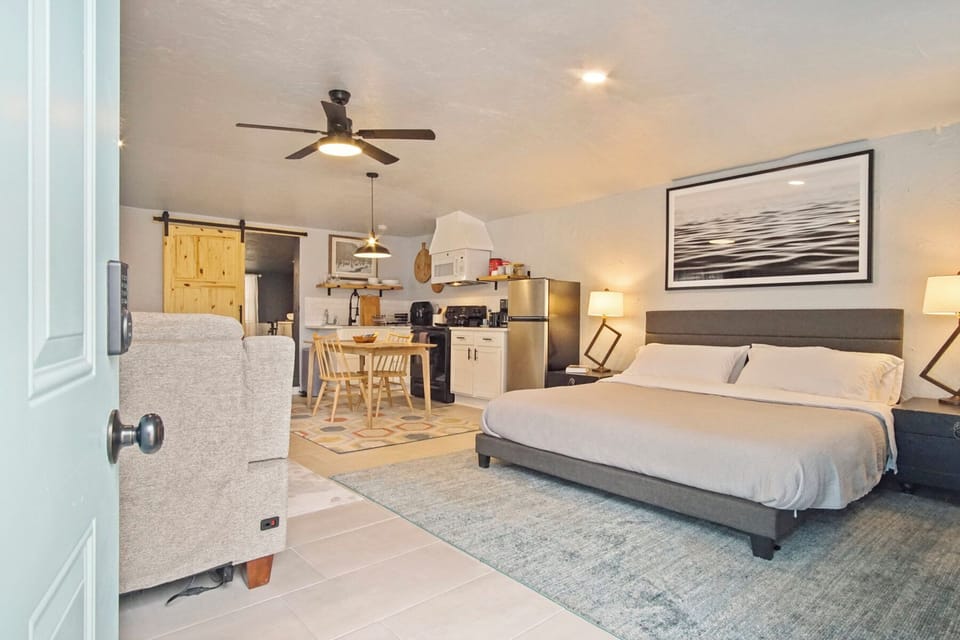 Comfortable bedroom with a cozy bed and easy access to the kitchen and living area.