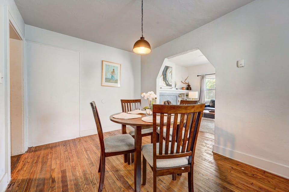 Inviting dining area with warm wood tones and an open view into the cozy living room.