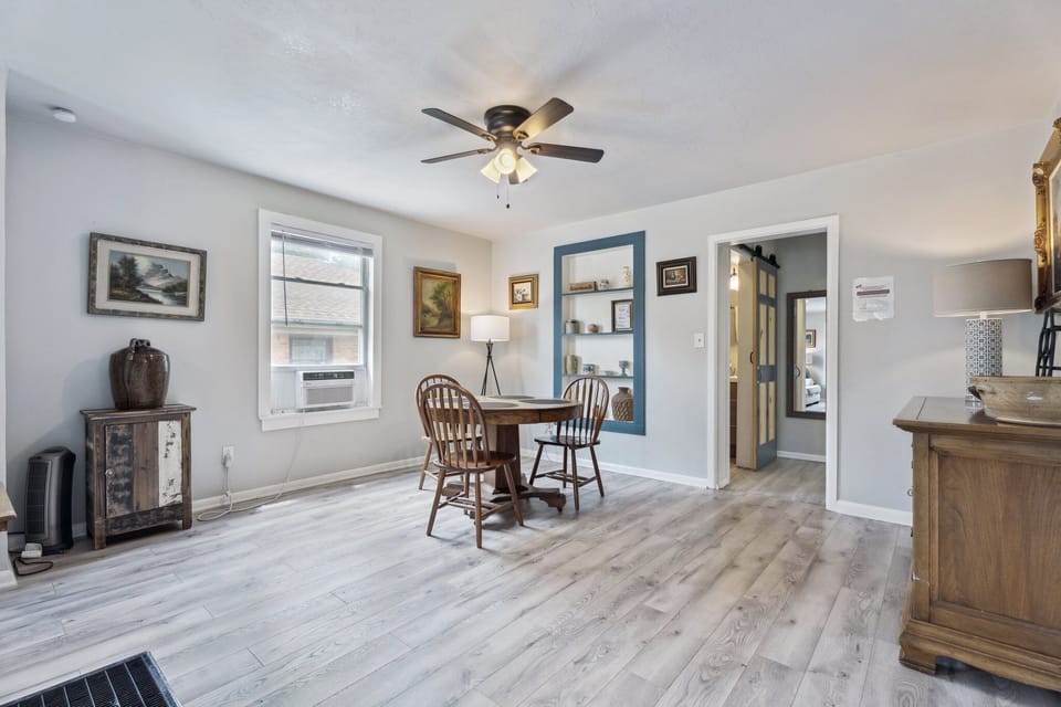 Dine beneath warm lighting in this welcoming space, accented by built-in shelves with charming vintage décor.