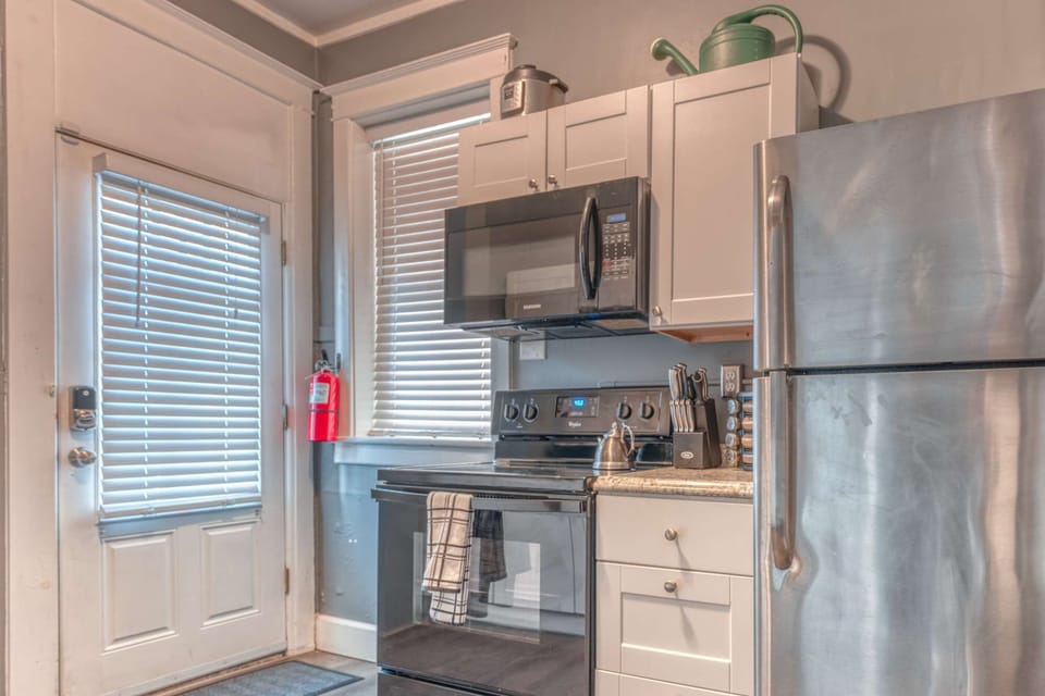 Compact kitchen w/ stainless finishes, open shelving &amp; convenient coffee setup