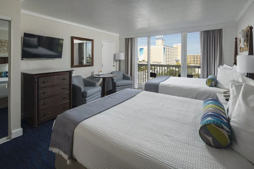 Unwind in plush beds with balcony views and sunshine.
