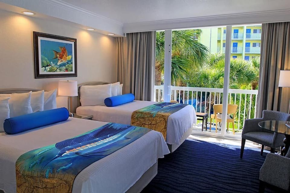 Unwind in crisp bedding with palms framed outside.