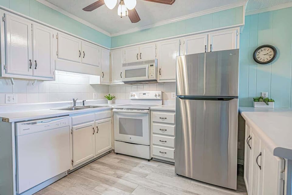 Kitchen includes cups, plates, utensils, and basic cookware