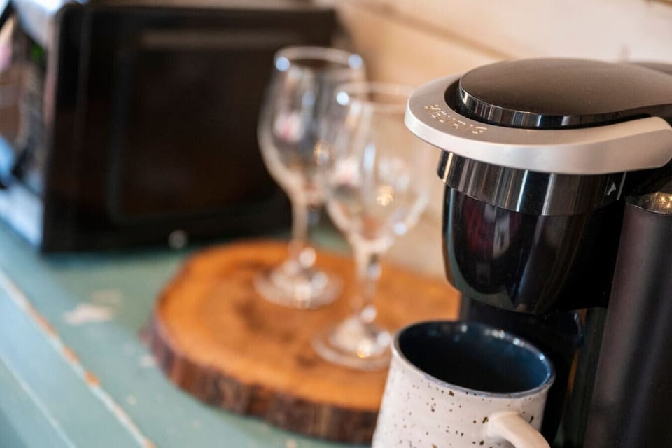 A Keurig is provided along with coffee mugs and wine glasses.