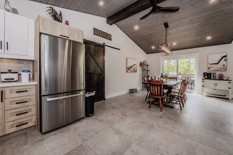 Enjoy open-concept kitchen and dining in an that area boasts modern amenities and rustic charm. The large dining table comfortably seats eight, perfect for family gatherings, while the kitchen provides all the essentials for meal preparation. 