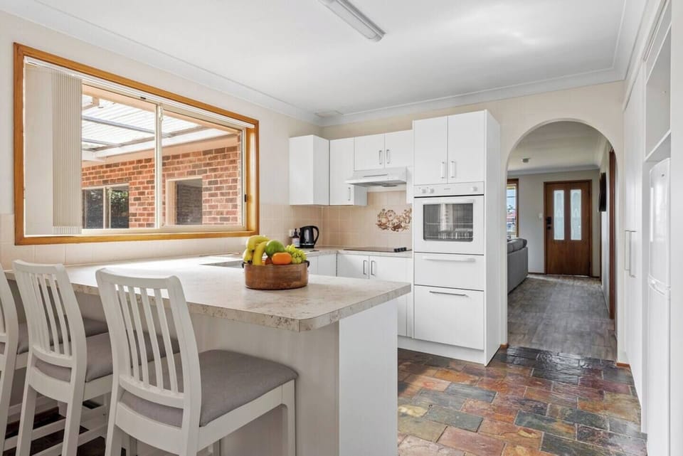 Open plan kitchen with oven, cooktop and refrigerator. Second refrigerator in garage for the drinks.