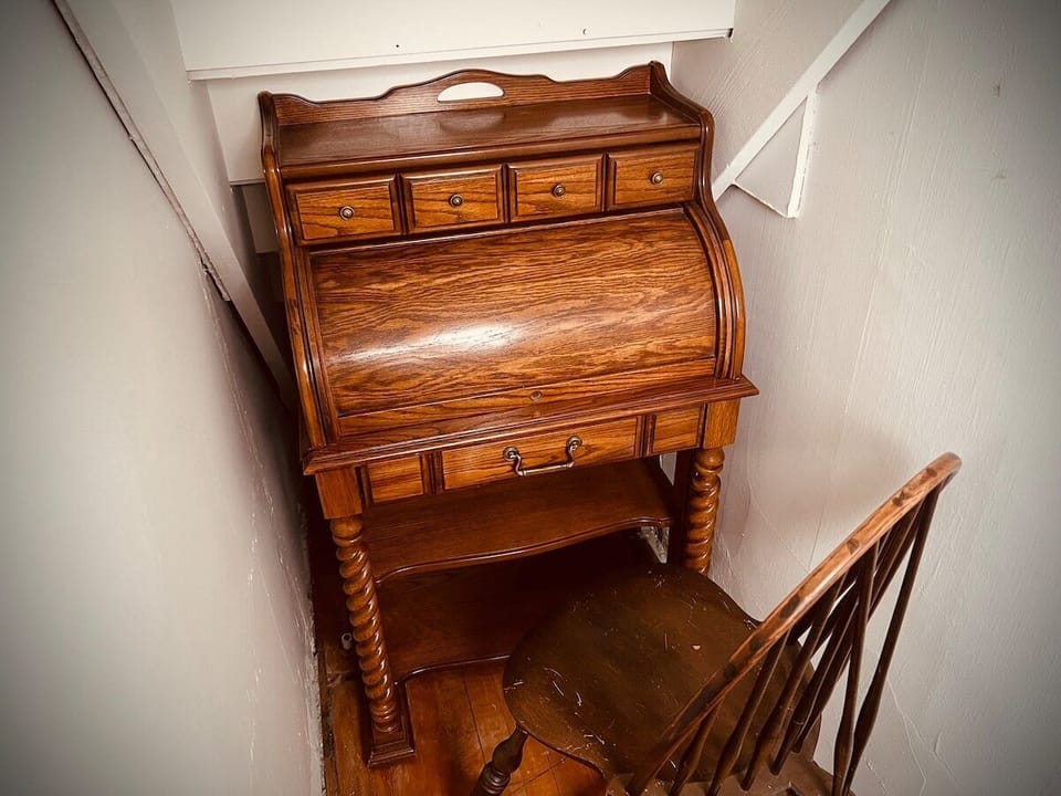 Antique roll top desk is a dedicated workspace in the primary room. 