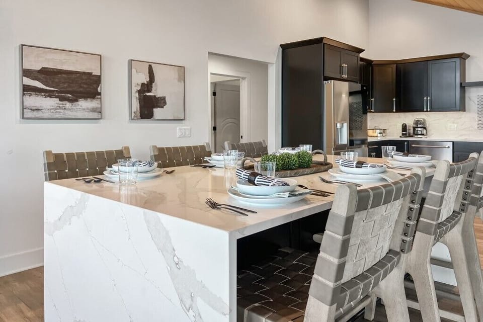 "Gather around the elegant dining table in a beautifully designed kitchen."

