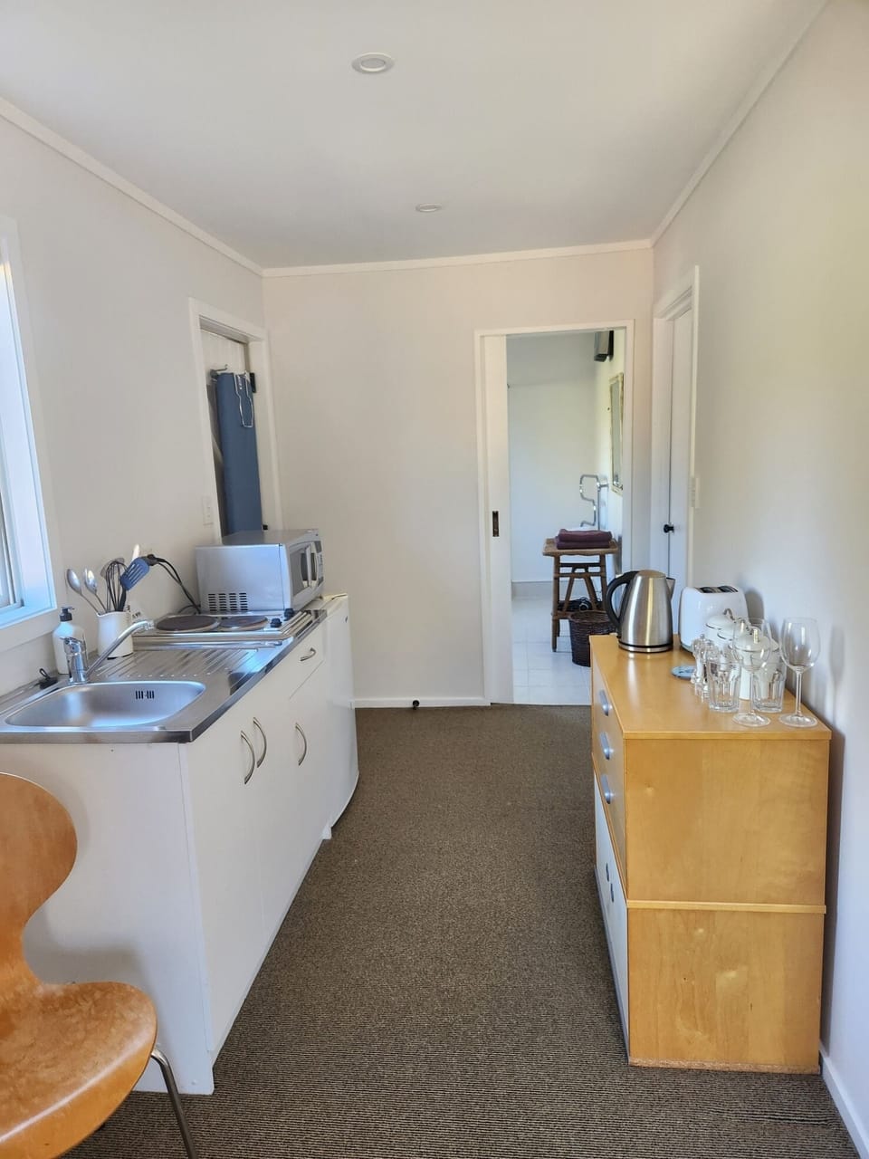 Kitchenette equipped with microwave, fridge and stove top.