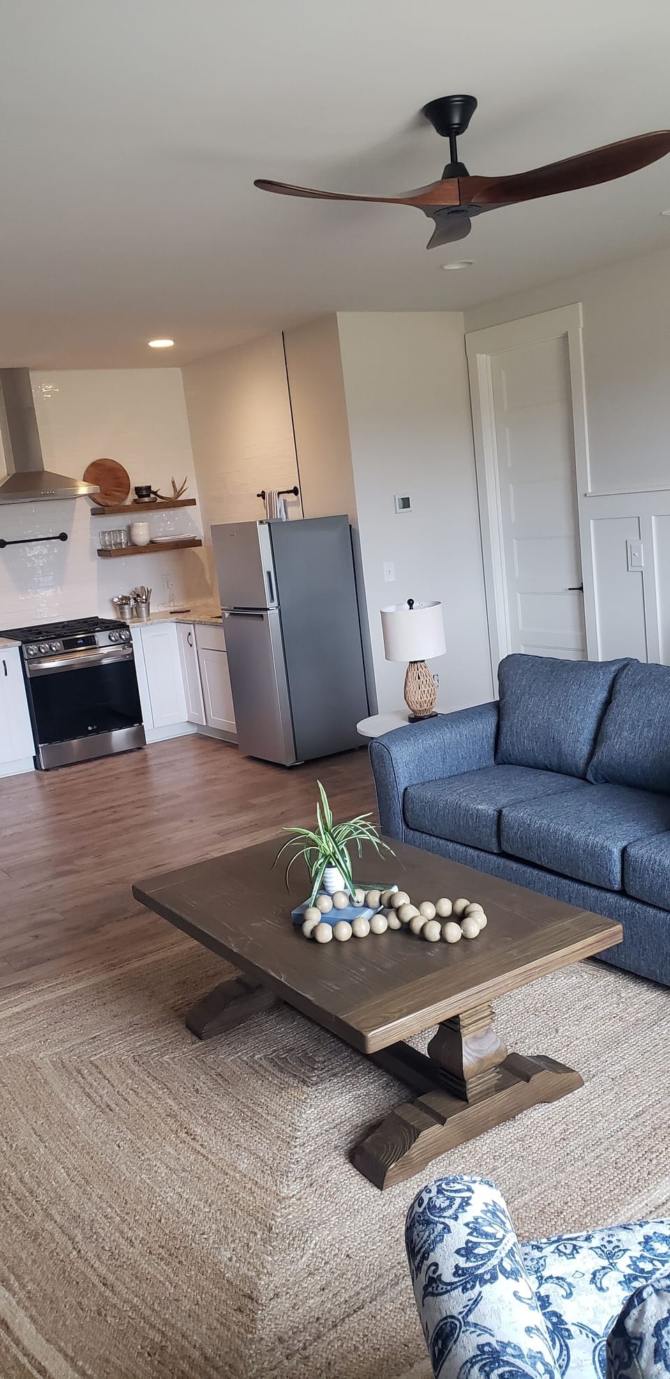 Living room with attached kitchen.  Bedroom door to right of kitchen.