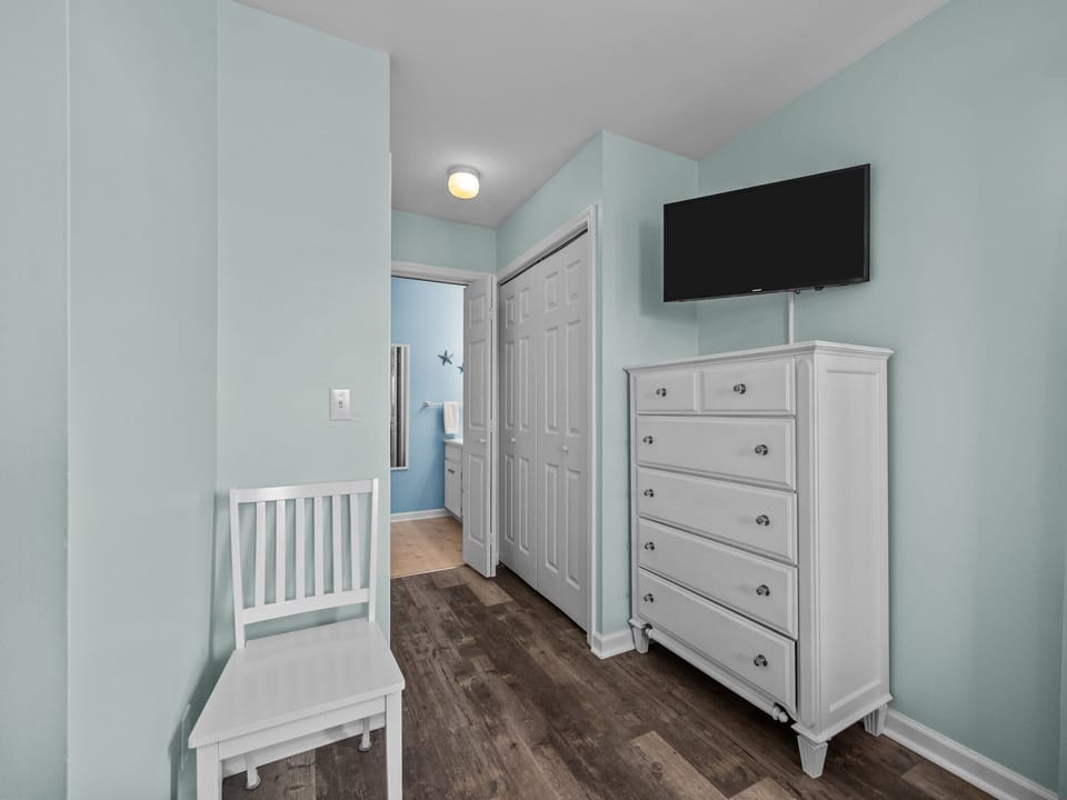 Spacious master bedroom with a king size bed, en suite bathroom, ceiling fan, closet, and a TV. (3)