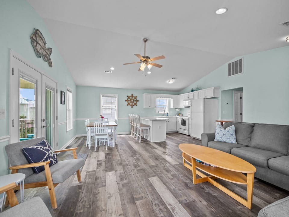 Living room with a big couch, extra chairs for seating, DVD's, puzzles, games, and ocean views. (3)