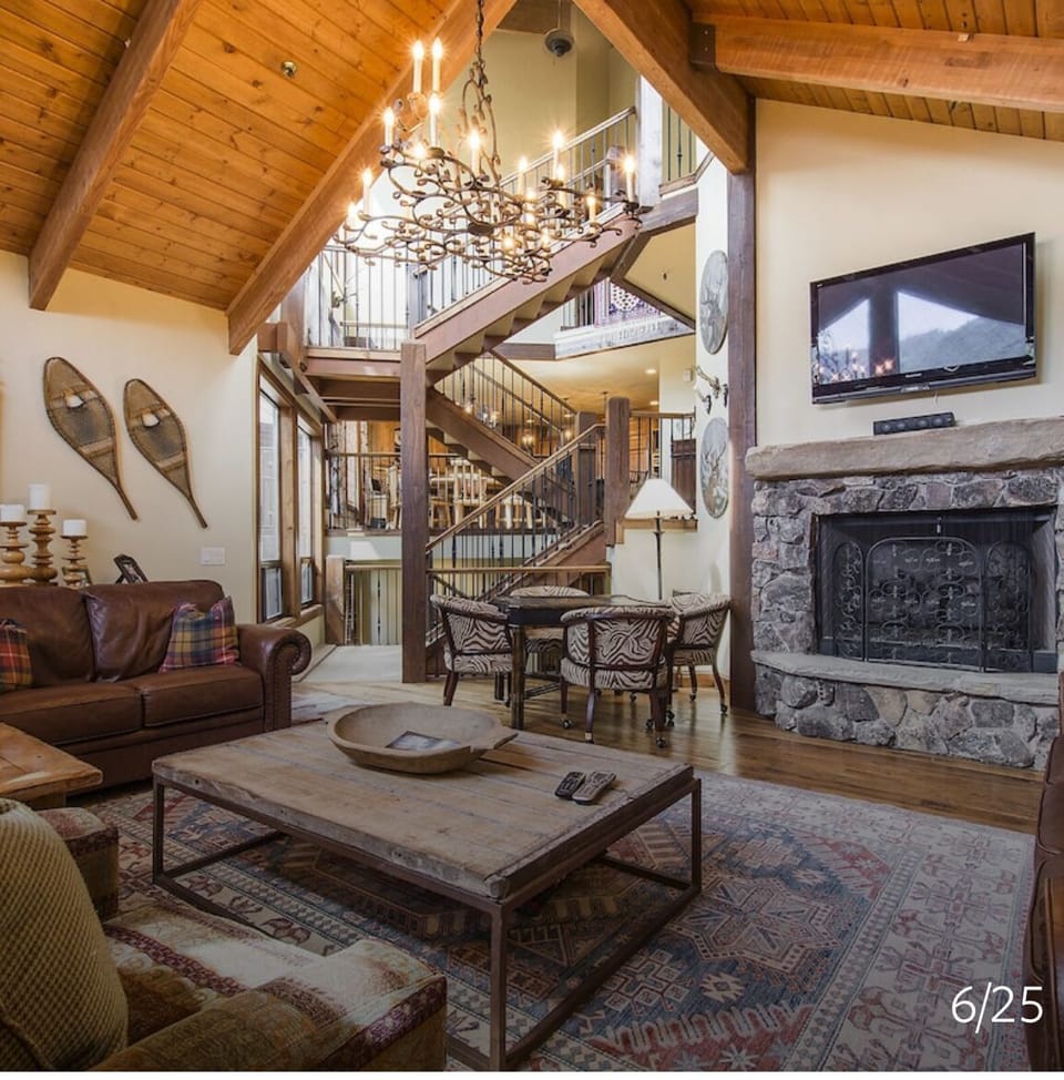 Great room with large fireplace, TV, game table.