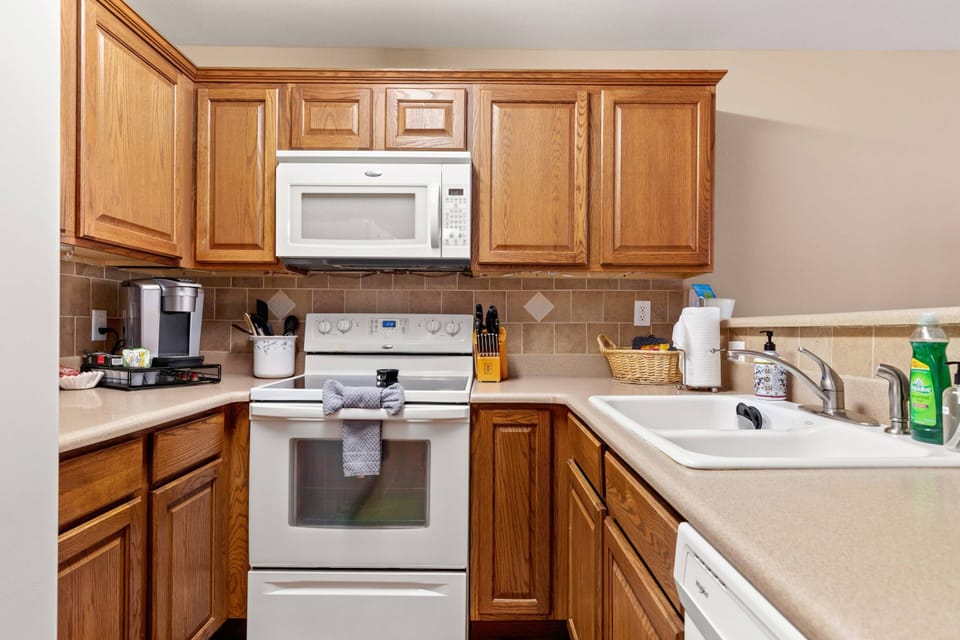 Start your day right with the convenience of a single-serve coffee maker in this well-appointed kitchen, offering complimentary coffee.