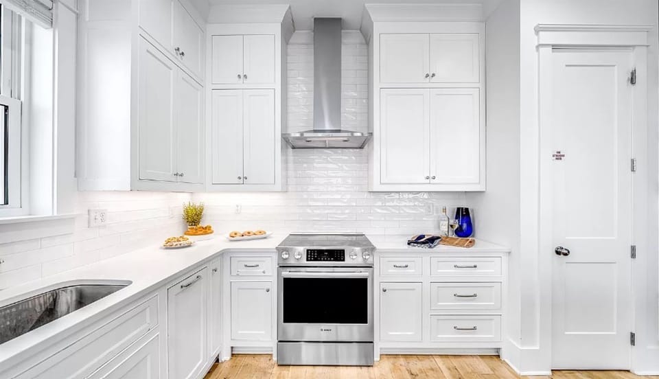 Step into your pristine white kitchen featuring gleaming countertops, modern stainless appliances, and abundant storage for all your culinary adventures.