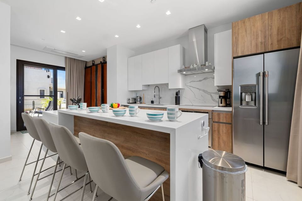 Get inspired by this stunning kitchen design, where contemporary white cabinets meet the natural beauty of a wooden cutting board!
