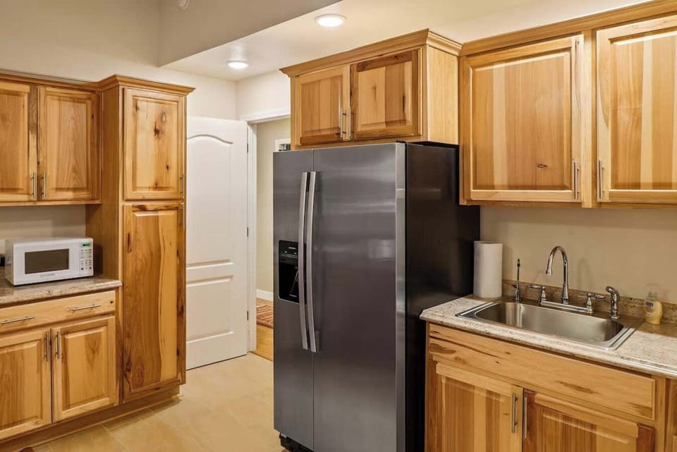 Mother in law kitchenette with full-sized refrigerator, sink, and microwave.