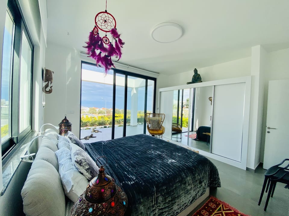 Schlafzimmer 1 mit traumhaftem Meerblick, großem Schrank und Bad en Suite