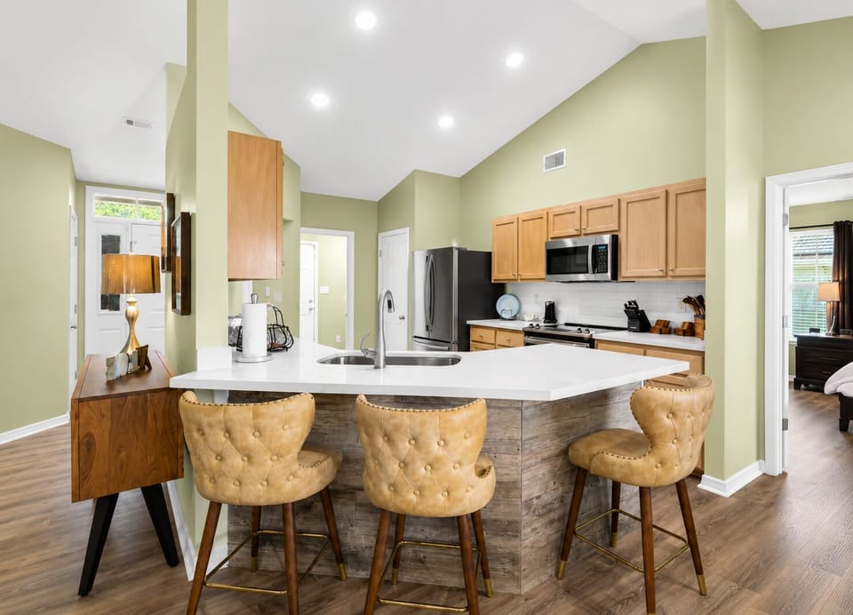 microwave, kitchen visible, coffee maker, oven, refrigerator, stovetop