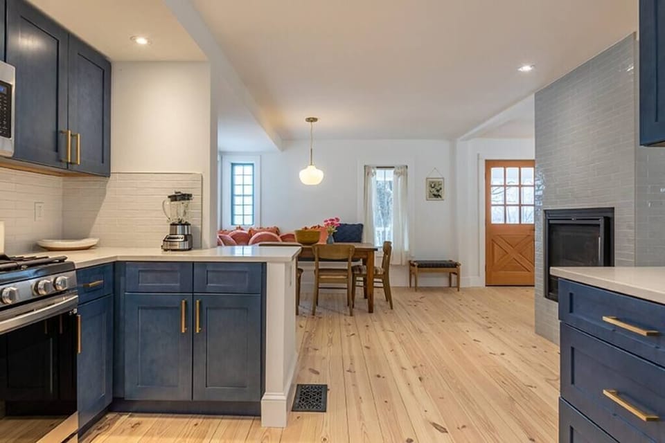 Kitchen view to breakfast nook and standing double sided fireplace 