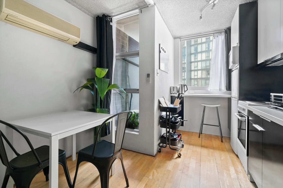 Neat little kitchen setup with a sunny window nook—perfect for breakfast or tea.  Compact, tidy, and easy living.