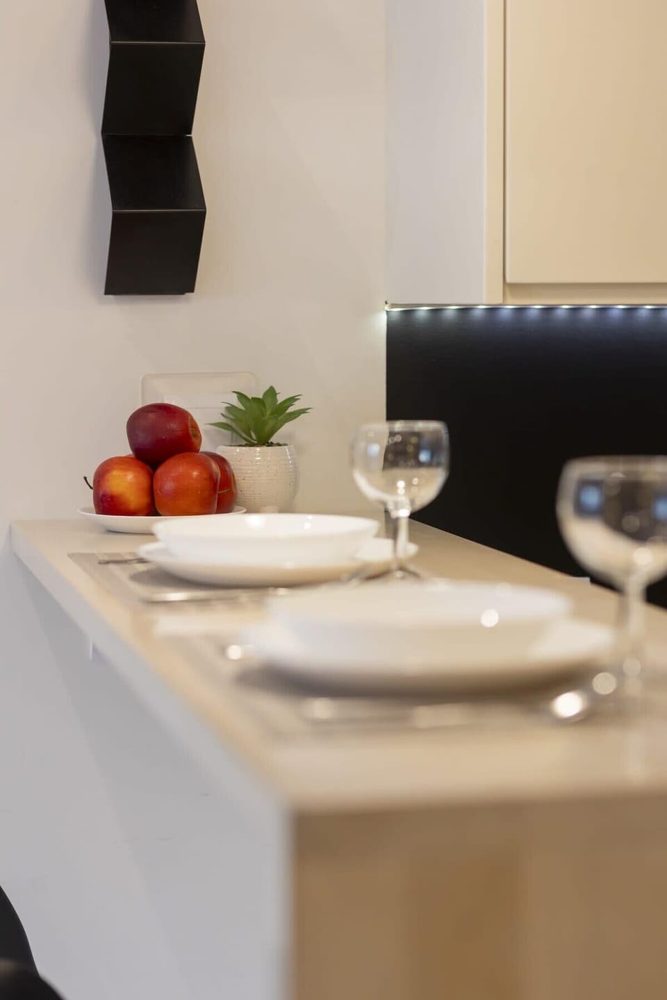 Close-up of a breakfast nook with a fresh apple, warm lighting, and minimalist tableware.
