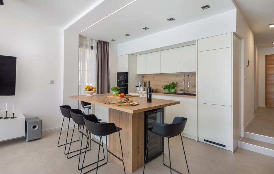 Modernly decorated living room with a fully equipped kitchen and a view of the sea