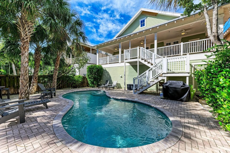 Dive into your private tropical oasis! Crystal-clear pool surrounded by swaying palms creates the perfect backyard paradise for relaxation and fun.