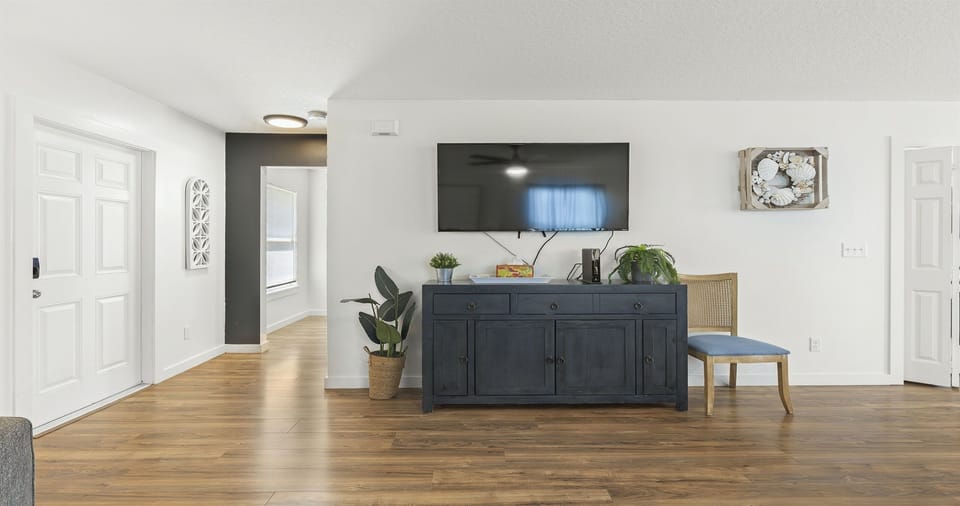 Cozy living space to unwind 📺🌿
Kick back on the comfy sectional, stream your favorite shows on the large TV, and enjoy the bright open layout—perfect for relaxing together after a full beach day.
