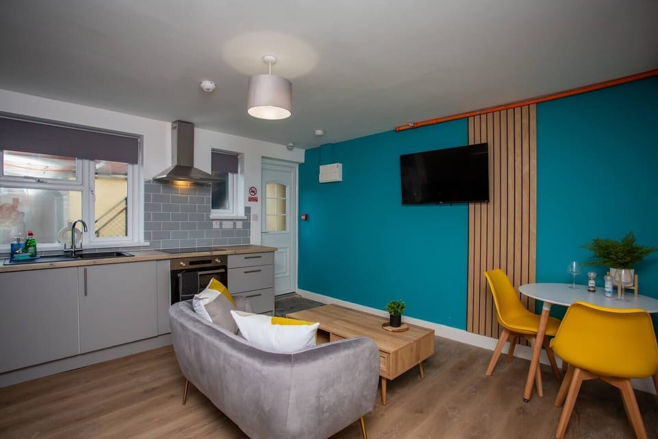 Living room with a state-of-the-art kitchen to assist in culinary endeavors, while a sleek heat extractor ensures a fresh and airy atmosphere as you cook up a storm