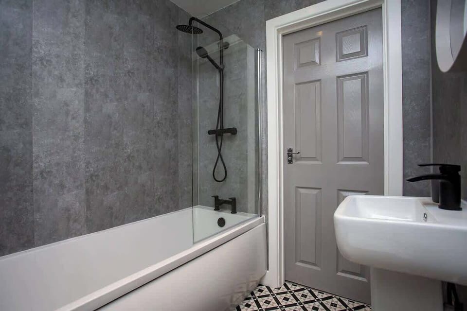 A deep soaking bathtub invites you to unwind and melt away the stresses of the day, surrounded by sleek tile and soft ambient lighting