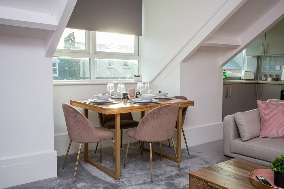 A sleek table for four awaits, surrounded by comfortable seating and bathed in natural light.