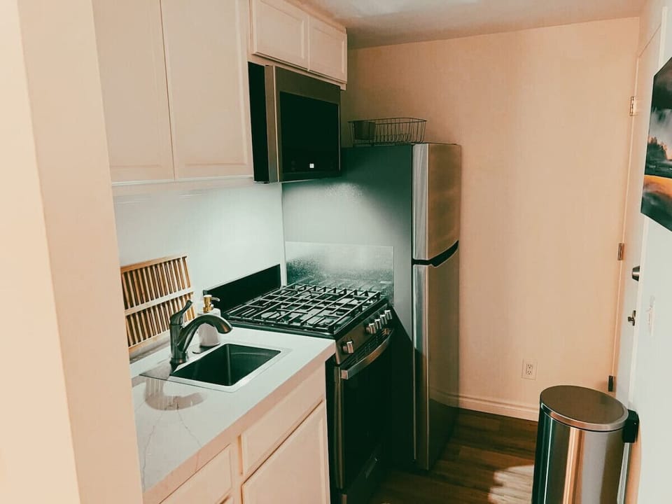 Our kitchen features a stainless steel microwave, oven/stove top, and fridge/freezer combo.