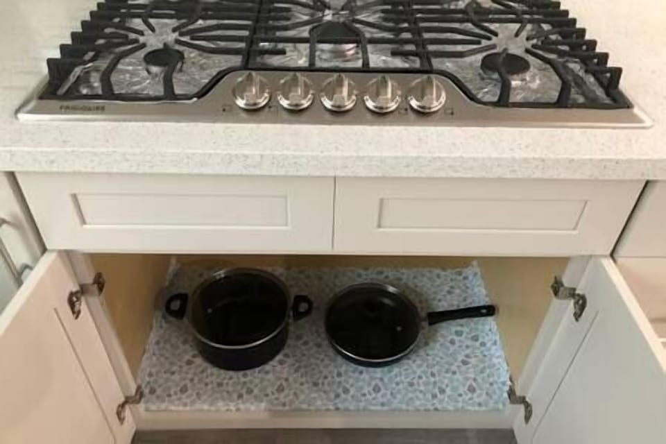 Stove top with cabinet of pot and pan. 