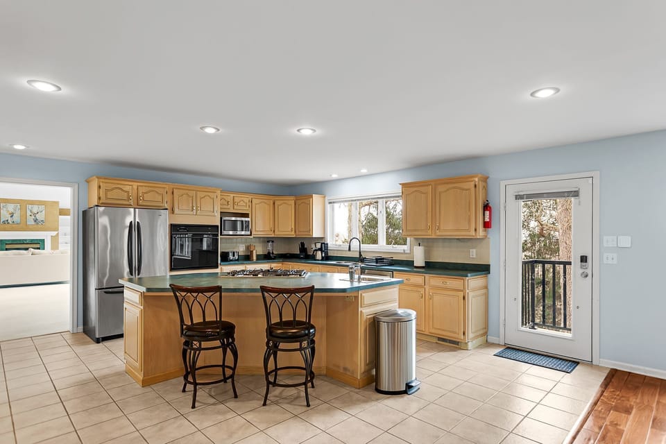 fully stocked kitchen with two counter barstools