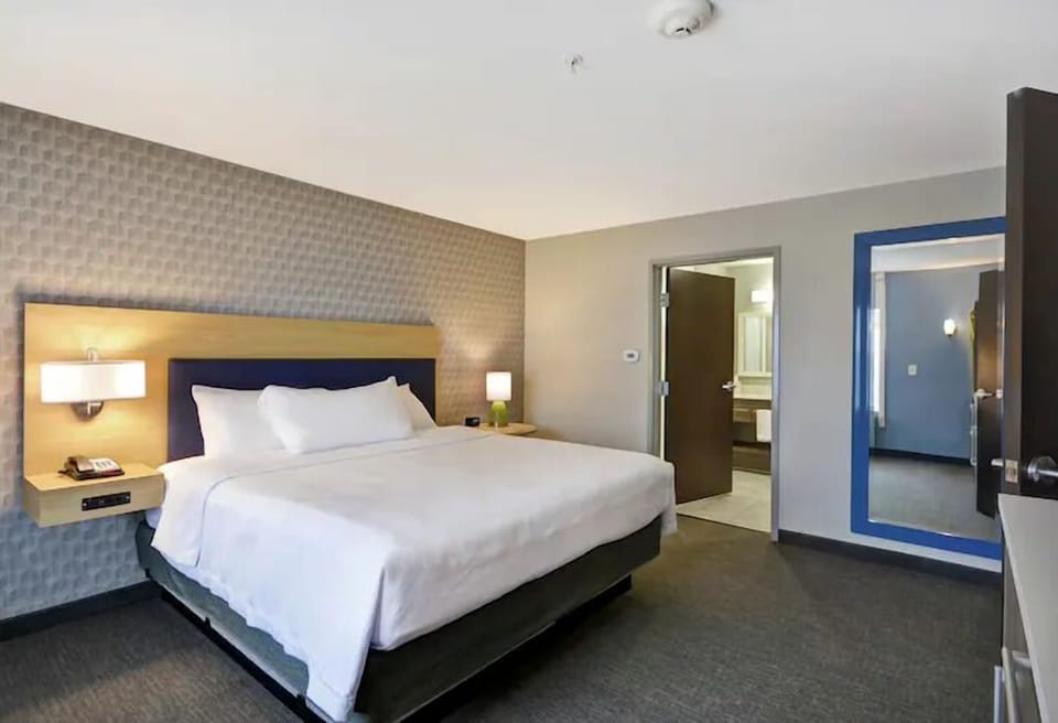 Unwind in a crisp, quiet bedroom with soft lighting.